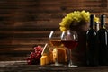 Glass of red and white wine, cheeses and grapes on brown wooden background Royalty Free Stock Photo