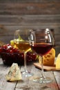 Glass of red and white wine, cheeses and grapes on grey wooden background Royalty Free Stock Photo