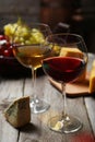 Glass of red and white wine, cheeses and grapes on a grey wooden background Royalty Free Stock Photo