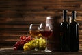 Glass of red and white wine with grapes on brown wooden background Royalty Free Stock Photo