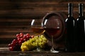 Glass of red and white wine with grapes on brown wooden background Royalty Free Stock Photo