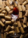 Glass of red wine against background of corks from wine bottles Royalty Free Stock Photo