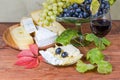 Glass of red wine against grapes and various cheese Royalty Free Stock Photo