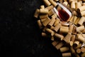 Glass of red wine on background of corks from wine bottles.Top view on black background with space for text and advertising. Royalty Free Stock Photo