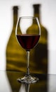 A glass of red wine on a background of two bottles Royalty Free Stock Photo