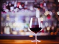 A glass of red wine on a bar lights background, enology abstraction Royalty Free Stock Photo
