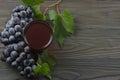 Glass of red wine with blue grapes and green leaf on dark wooden table. Top view with copy space Royalty Free Stock Photo