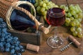Glass with red wine,  bottle, bunch of grapes,  corkscrew on  wooden table Royalty Free Stock Photo