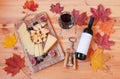Glass of red wine, bottle of red wine, corkscrew,  figs, cheese and  autumn maple leaves Royalty Free Stock Photo