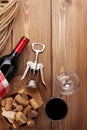 Glass of red wine, bottle and corkscrew on rustic wooden table Royalty Free Stock Photo