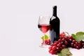 Glass of red wine, bottle and grapes on white background with copy space Royalty Free Stock Photo