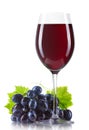 Glass of red wine with bottle and ripe grapes isolated