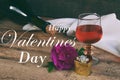 A glass of red wine, bottle and rose on rustic wood table. Valentine`s day still life. Concept greeting card with the inscription Royalty Free Stock Photo