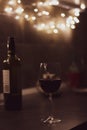 Glass of red wine and bottle at the table. Evening still life. Red wine in bar. Alcohol drinks concept. Wineglass and wine bottle. Royalty Free Stock Photo