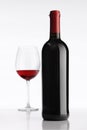 Glass with red wine bottle on white background