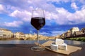 Glass of red wine and brie cheese with view of bridge in Florence during sunset - Ponte alla Carraia, five-arched bridge over