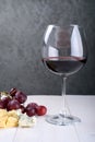 A glass of red wine, a bunch of grapes and cheese Royalty Free Stock Photo