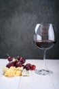 A glass of red wine, a bunch of grapes and cheese Royalty Free Stock Photo