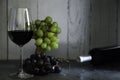 Glass of red wine and bunch of red and white grapes