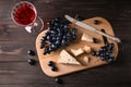 Glass of red wine with cheese and fresh grapes on wooden table Royalty Free Stock Photo