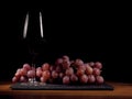 Glass of red wine and cluster of red grapes. Royalty Free Stock Photo