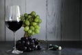 Glass of red wine corkscrew and grape clusters