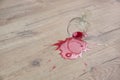 Glass of red wine fell on laminate, wine spilled on floor Royalty Free Stock Photo