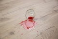 Glass of red wine fell on laminate, wine spilled on floor Royalty Free Stock Photo