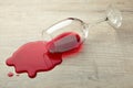 Glass of red wine fell on laminate, wine spilled on floor Royalty Free Stock Photo