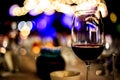 Glass of Red Wine on the food table with Lights Bokeh.