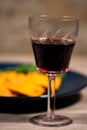 Glass of red wine in front of a plate of ravioli