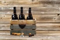 Glass of red wine and full bottles in wood crate on rustic woode Royalty Free Stock Photo