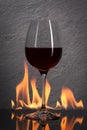Glass. Red wine glass with fire splash in front of stone granit Royalty Free Stock Photo