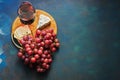 A glass of red wine, grapes, cheese, blue cheese on a cutting board, blue background. Top view, copy space Royalty Free Stock Photo