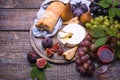 A glass of red wine, grapes, cheese, cork, corkscrew, white bread on a dark background Royalty Free Stock Photo