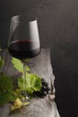 A glass of red wine, grapes and grape leaves on an old wooden table Royalty Free Stock Photo