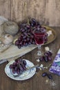 Glass of red wine with grapes on a wooden background.