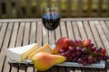 Glass of red wine with grapes on wooden table Royalty Free Stock Photo
