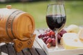 Glass of red wine with grapes on wooden table Royalty Free Stock Photo