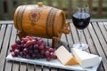Glass of red wine with grapes on wooden table Royalty Free Stock Photo