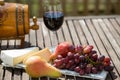 Glass of red wine with grapes on wooden table Royalty Free Stock Photo