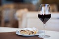 Glass of red wine and Linzer cake in cafe. Hiking in Dolomites, Italy