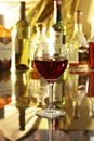 Glass of red wine on mirror table. bottles in a bar on the background Royalty Free Stock Photo