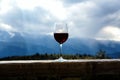 Glass of red wine and mountains on background. Royalty Free Stock Photo