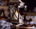 Glass with red wine. Near broken chocolate. Lantern with a candle in the background Royalty Free Stock Photo