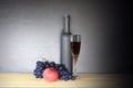 Glass of red wine near wine bottle next to apple and bunch of grapes Royalty Free Stock Photo