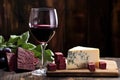 a glass of red wine next to a block of cheese on a rustic table