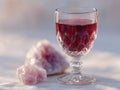 A glass of red wine next to a pile of pink crystals Royalty Free Stock Photo