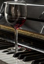 Glass of red wine on piano keyboard. Music and wine concept Royalty Free Stock Photo