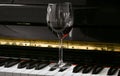 Glass of red wine on piano keyboard. Music and wine concept Royalty Free Stock Photo